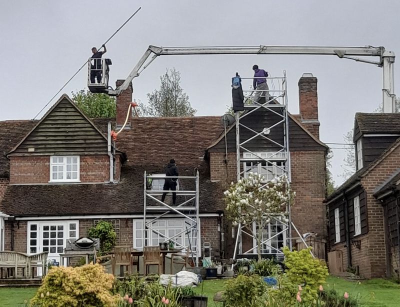 The Roof Moss Cleaners using cherry picker and scaffolding to clean roof safely and professionally in Farnham, Surrey